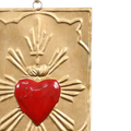 Decorative plaque with a red heart and gold rays on a white background
